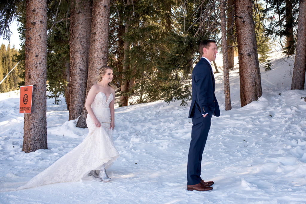 Bride in boots walking in snow to first look with groom at Breckenridge Ski Resort