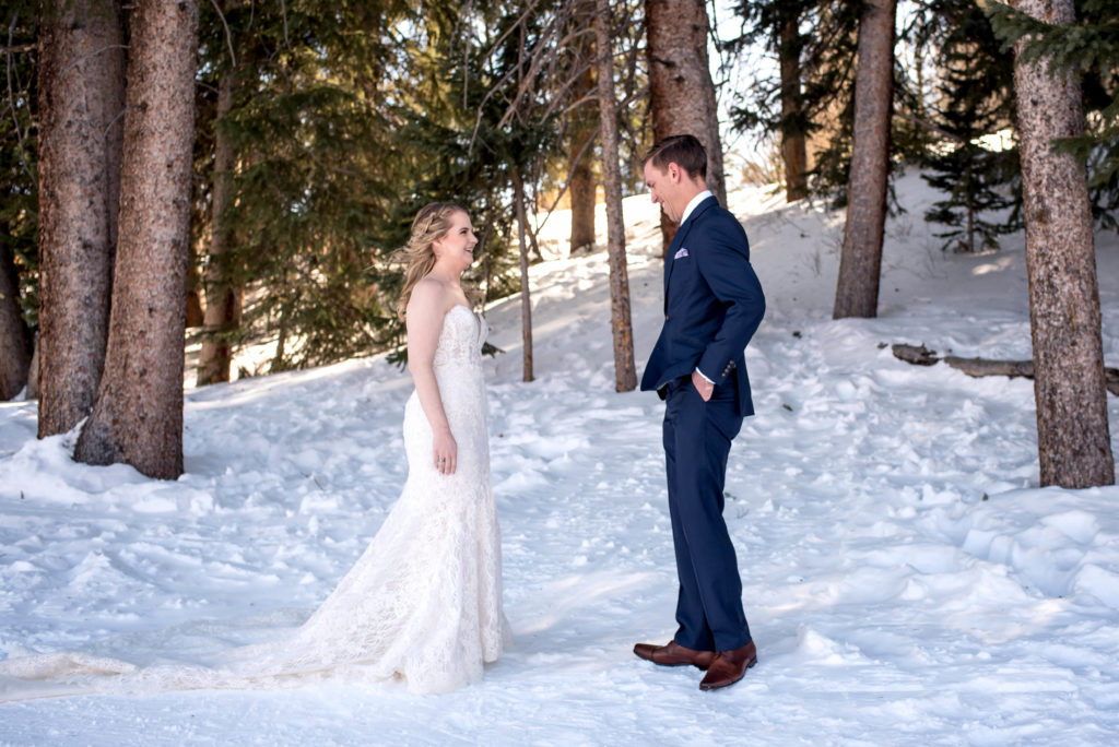 Bride and groom's first look in the snow at Breckenridge Ski Resort in the woods