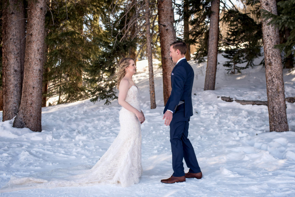 Bride and groom's first look in the snow at Breckenridge Ski Resort in the woods during their Colorado winter elopement day