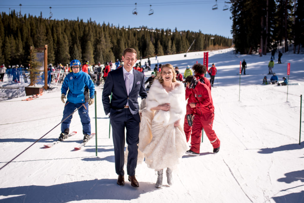 Couple walking through chairlift line to go to the top of Breckenridge Ski Resort Mountain for their Colorado winter elopement in Breckenridge