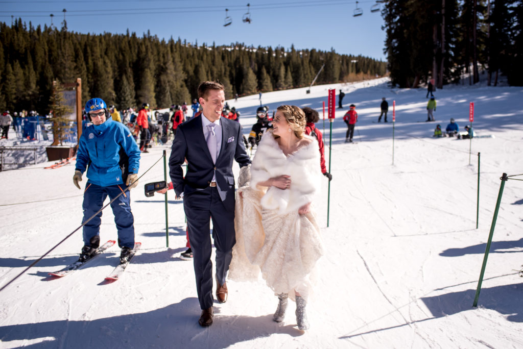 Couple walking through chairlift line to go to the top of Breckenridge Ski Resort Mountain for their Colorado winter elopement in Breckenridge