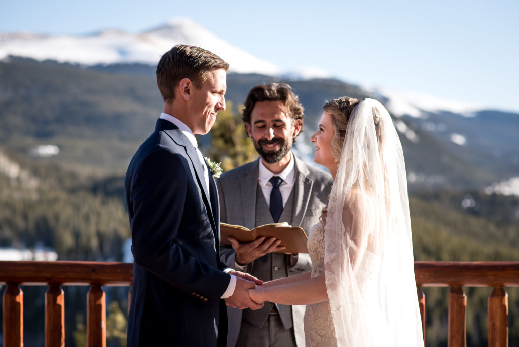 Exchanging rings during winter Colorado ceremony at The Lodge at Breckenridge