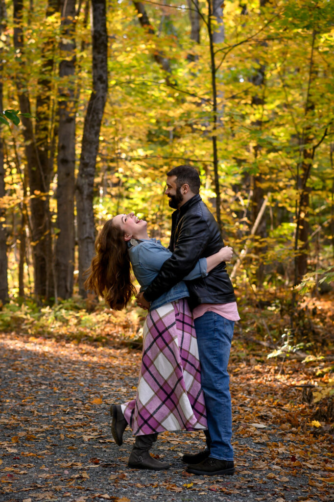 Couple holding eachother and laughing in a Sunapee trail in NH