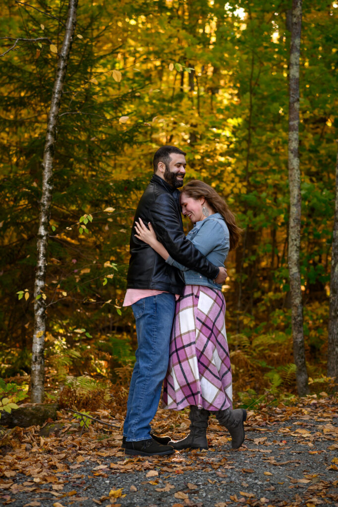 Couple laughing in embrace during their engagement photos in Sunapee