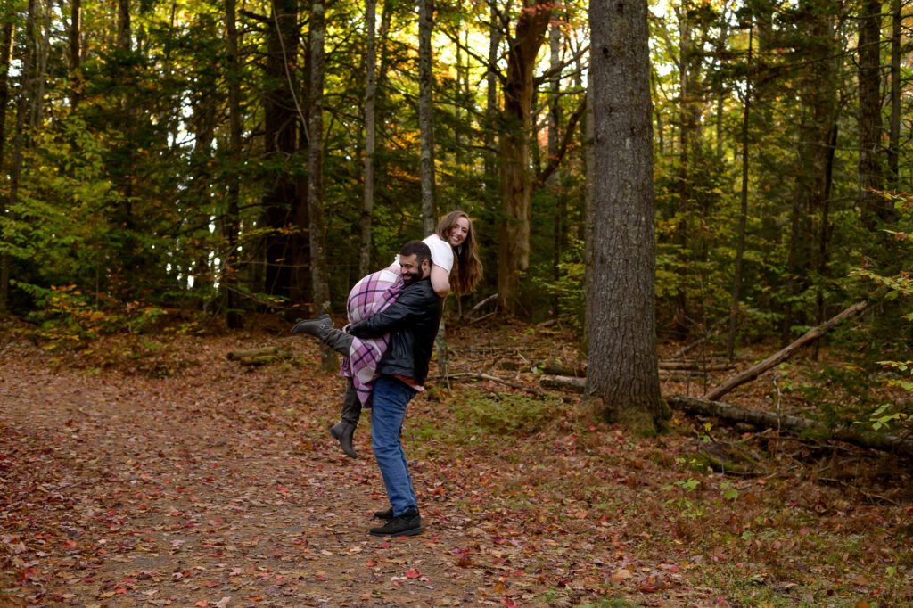 Couple in playful lift in the woods of nh