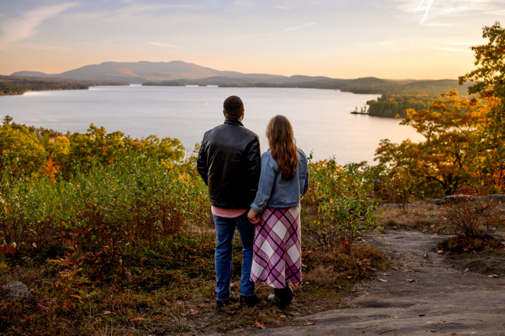Romantic engagement photo overlooking Lake Sunapee in fall