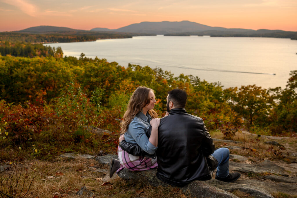 couple sitting and looking towards eachother on a rocky foreground