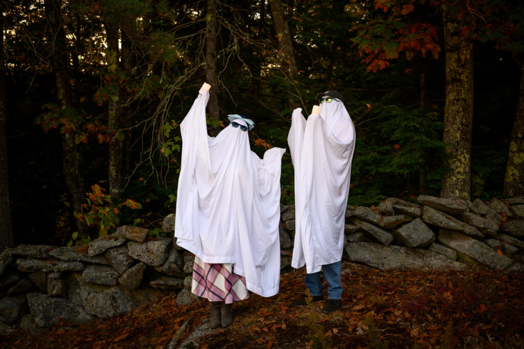 Funny ghost sheet engagement photo in the woods at dusk