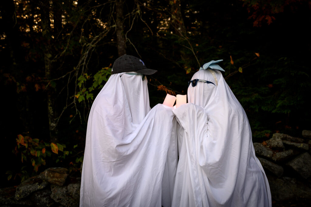 Couple wearing ghost sheets for Halloween themed engagement photos